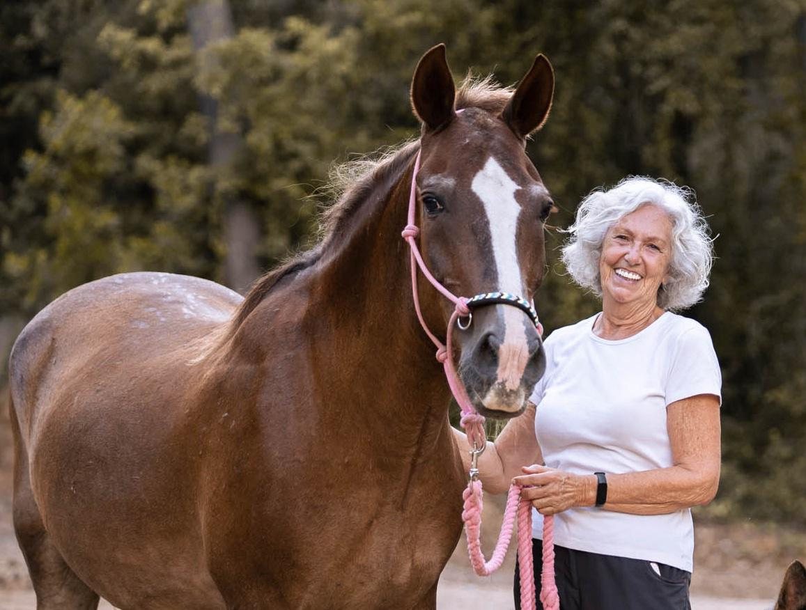 Retrato de Anna Álvarez Crispi sonriendo junto a un caballo alazán