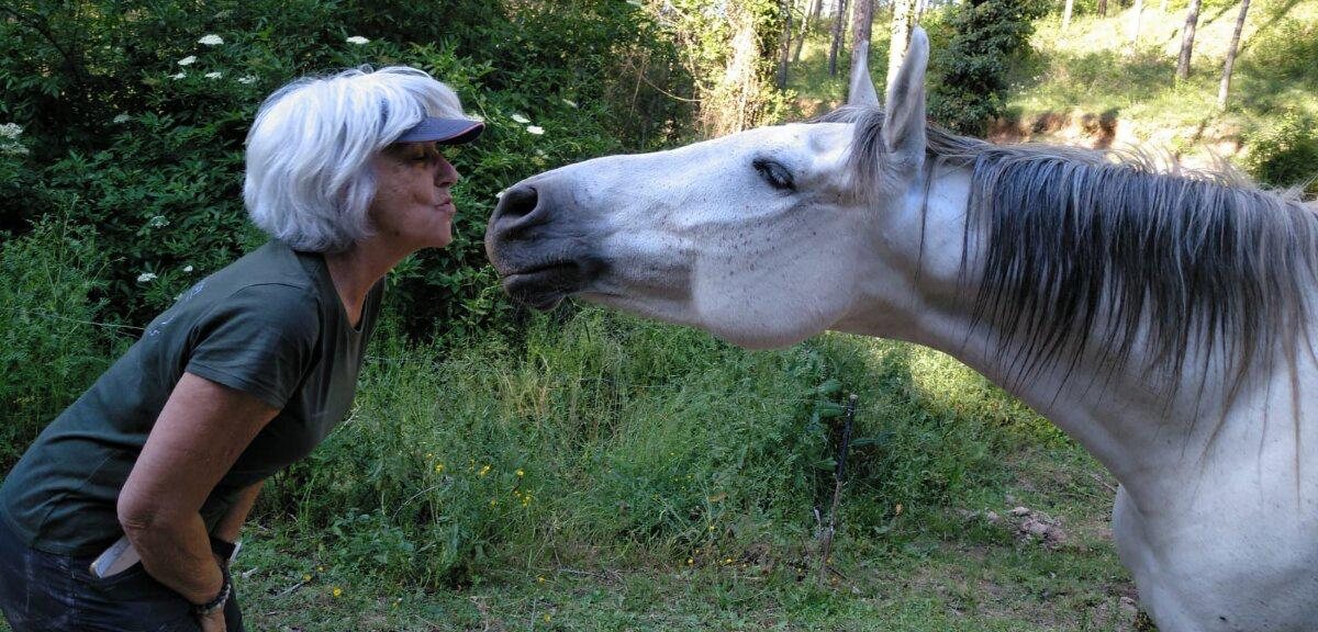 Anna Álvarez Crispi y un caballo blanco frente a frente, acercándose con calma